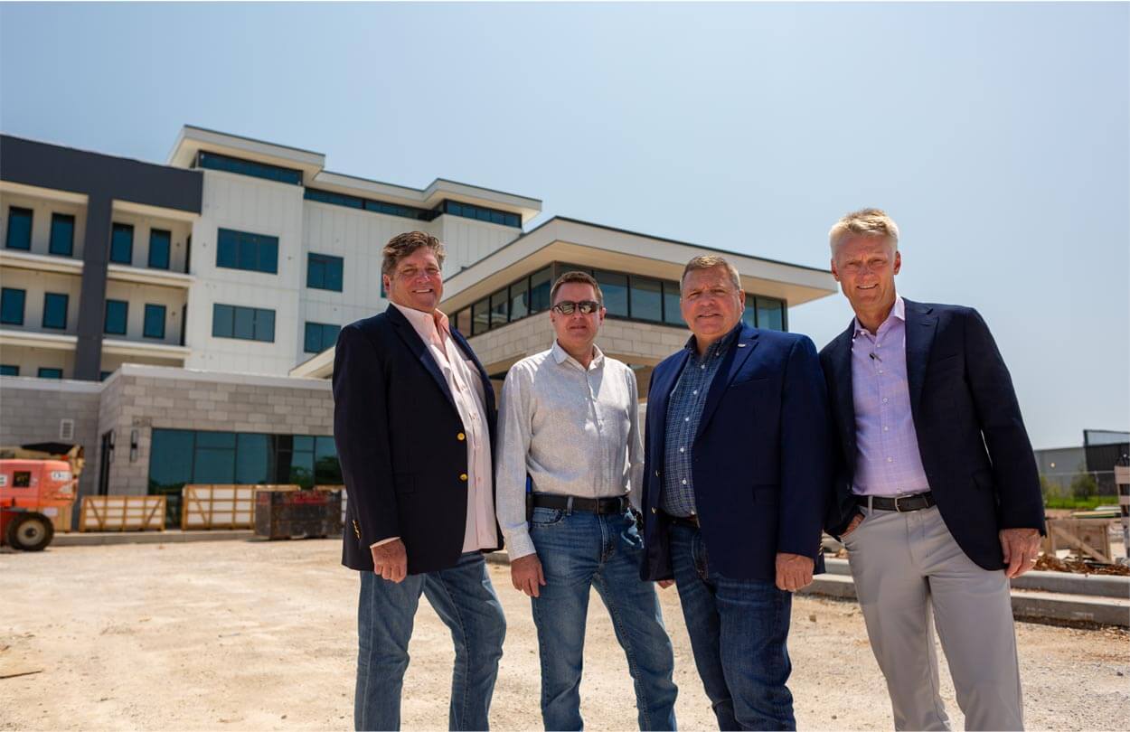 Group of men standing in front of a building under construction